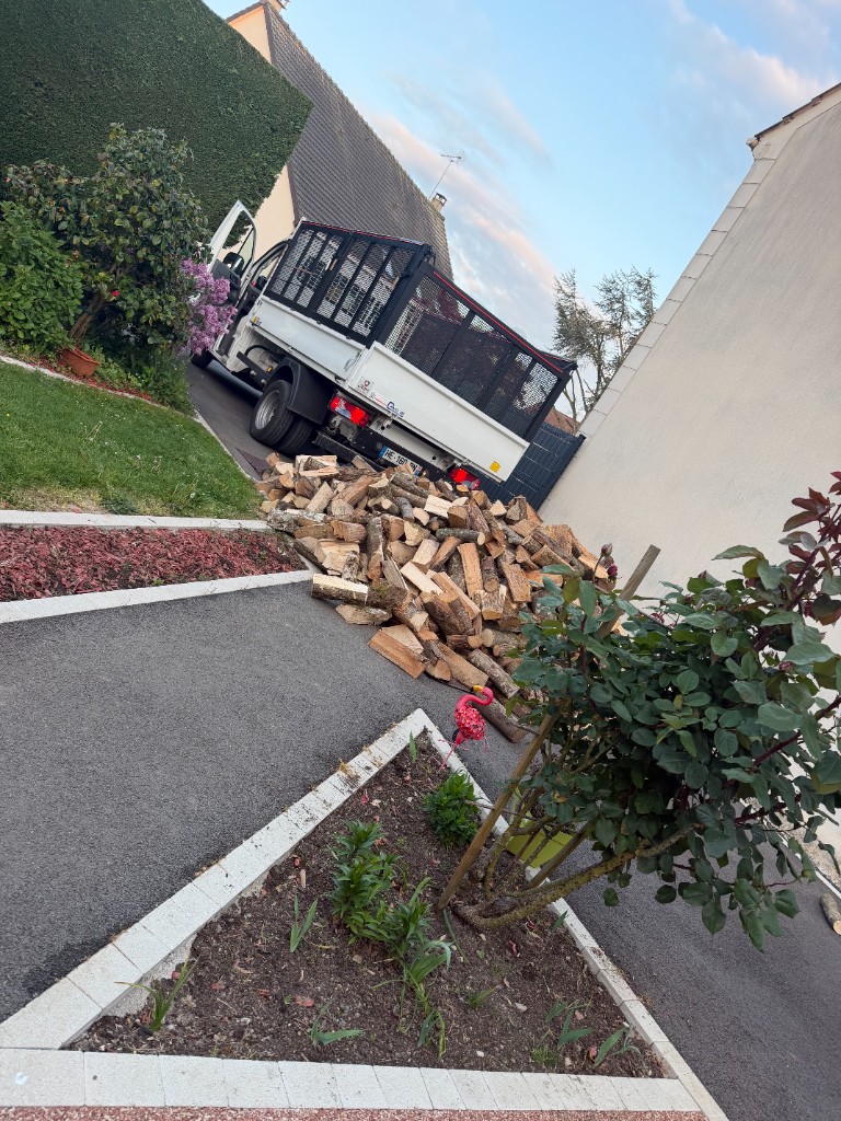 Livraison de bois de chauffage devant une maison